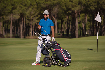 Image showing golf player walking with wheel bag