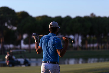 Image showing golfer from back at course looking to hole in distance