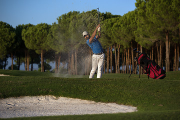 Image showing golfer hitting a sand bunker shot on sunset