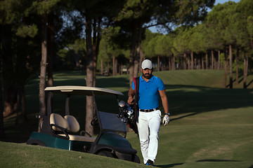 Image showing golfer  walking and carrying golf  bag