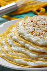 Image showing Pile of crepes with cottage cheese and grated coconut