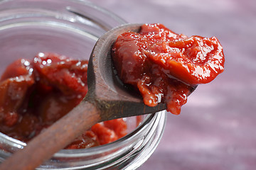 Image showing Plum jam on a wooden spoon