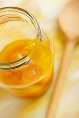 Image showing Yellow mirabelle plum jam blob over glass jar screw