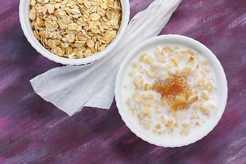 Image showing Porridge with milk and brown sugar and raw rolled oats