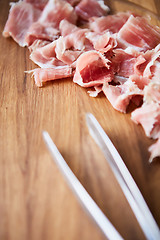 Image showing sliced prosciutto on a wooden board