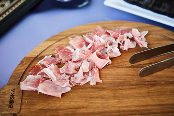 Image showing sliced prosciutto on a wooden board