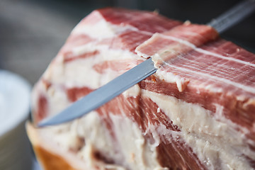 Image showing Chef slices serrano ham.