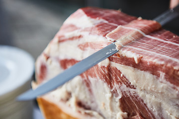 Image showing Chef slices serrano ham.