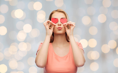 Image showing happy young woman with red heart shapes on eyes