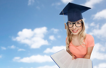 Image showing student woman in mortarboard with encyclopedia