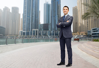 Image showing happy smiling businessman in suit over dubai city