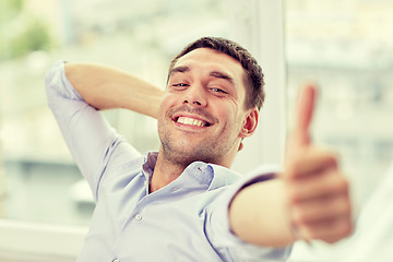 Image showing smiling man showing thumbs up at home or office