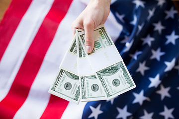 Image showing close up of hand with money over american flag