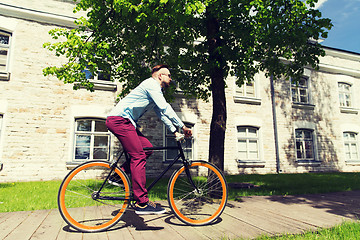 Image showing happy young hipster man riding fixed gear bike