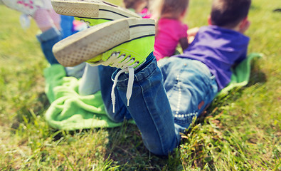 Image showing close up of kids lying on picnic blanket outdoors
