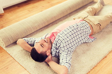 Image showing happy man lying carpet or rug at home