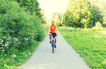 Image showing happy young man riding bicycle outdoors