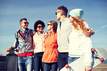 Image showing happy teenage friends with longboards on street