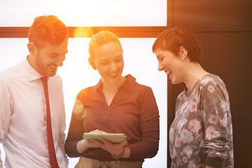 Image showing young business people group working on tablet computer with sunr