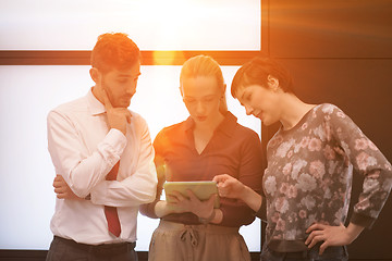 Image showing young business people group working on tablet computer with sunr