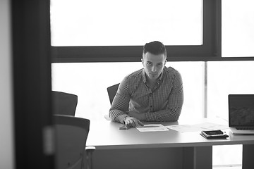 Image showing young businessman at his desk in office