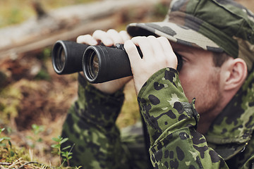 Image showing young soldier or hunter with binocular in forest