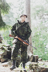 Image showing young soldier or hunter with gun in forest