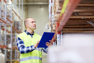 Image showing man with clipboard in safety vest at warehouse