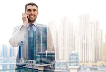 Image showing young smiling businessman calling on smartphone