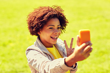 Image showing happy african woman taking selfie with smartphone