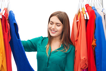 Image showing happy woman choosing clothes at home wardrobe