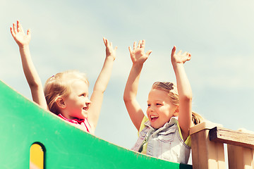 Image showing happy girls waving hands on children playground