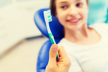 Image showing close up of dentist hand with toothbrush and girl