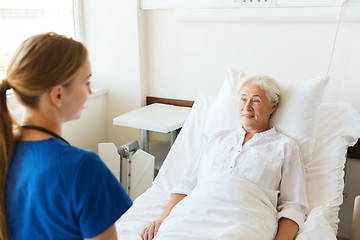 Image showing doctor or nurse visiting senior woman at hospital