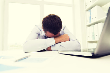 Image showing businessman with laptop and papers in office