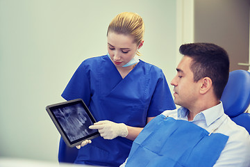 Image showing female dentist with tablet pc and male patient