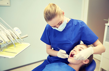 Image showing female dentist checking patient girl teeth