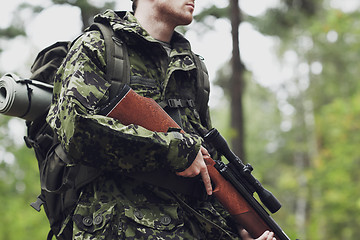 Image showing close up of soldier or hunter with gun in forest