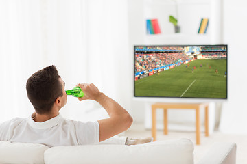 Image showing man watching soccer game on tv and drinking beer