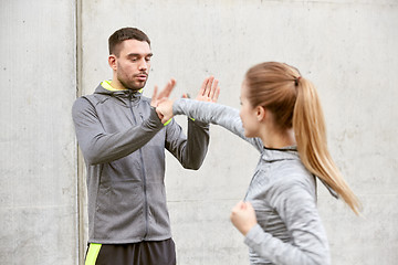 Image showing woman with trainer working out self defense strike