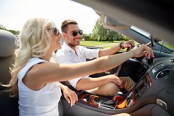 Image showing happy couple using gps navigator in cabriolet car