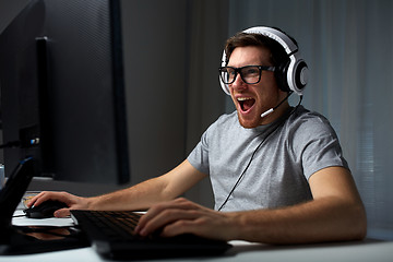 Image showing man in headset playing computer video game at home