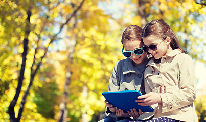 Image showing happy girls with tablet pc computer outdoors