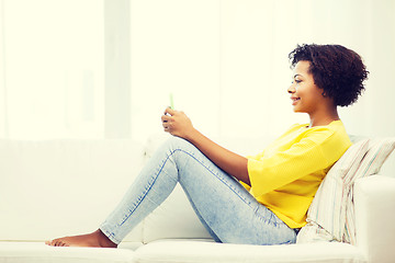 Image showing happy african woman with smartphone at home