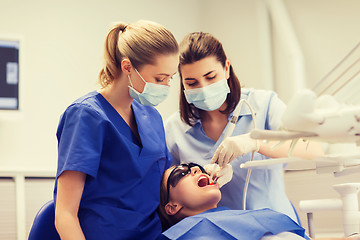 Image showing female dentists treating patient girl teeth