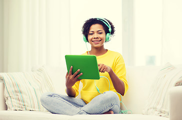 Image showing happy african woman with tablet pc and headphones