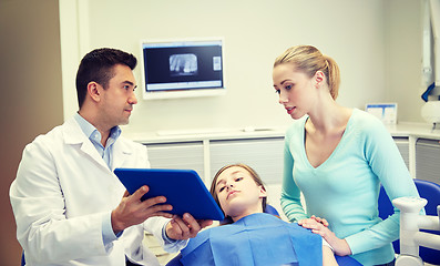 Image showing dentist showing tablet pc to girl and her mother