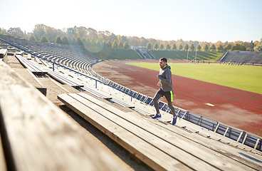 Image showing happy young man running upstairs on stadium