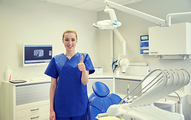 Image showing happy female dentist showing thumbs up at clinic