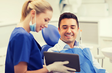 Image showing female dentist with tablet pc and male patient